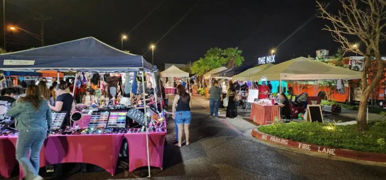 people walking around a street with tents