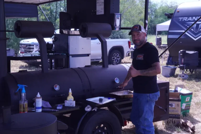 a man standing next to a grill