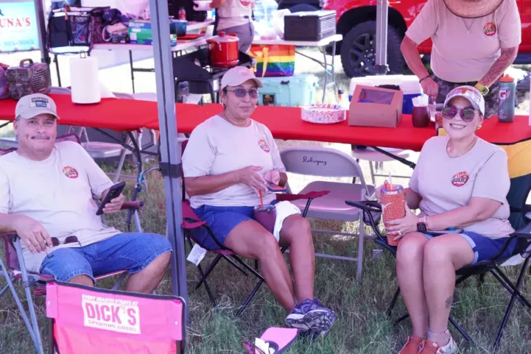 a group of people sitting in chairs under a tent
