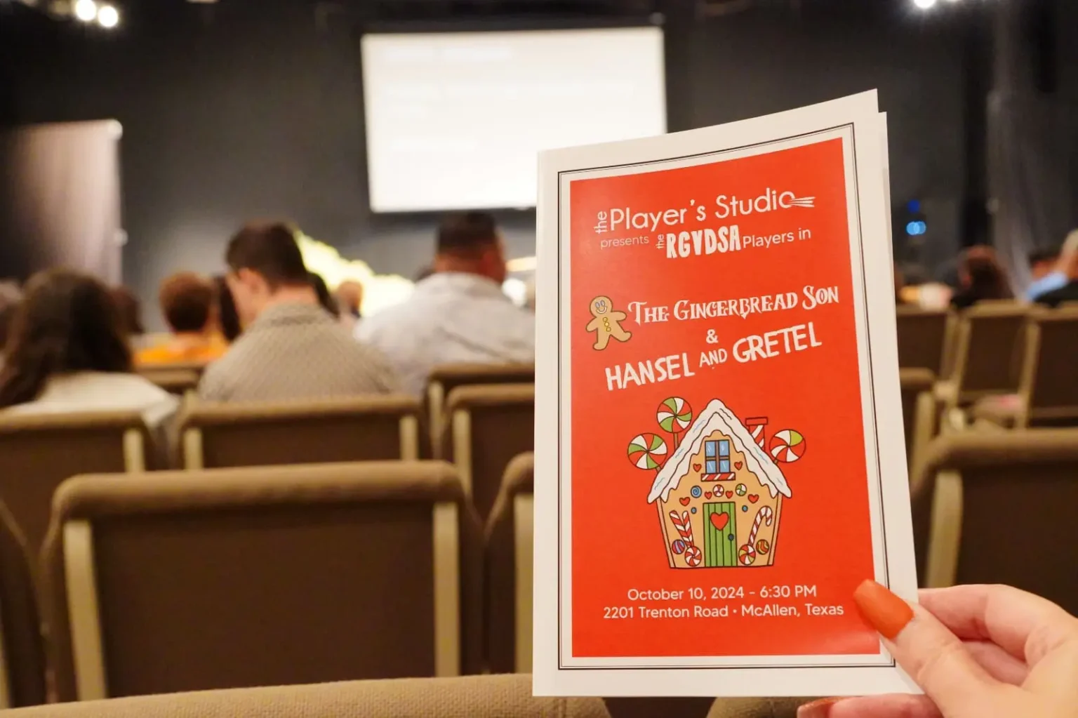 a hand holding a red and white card