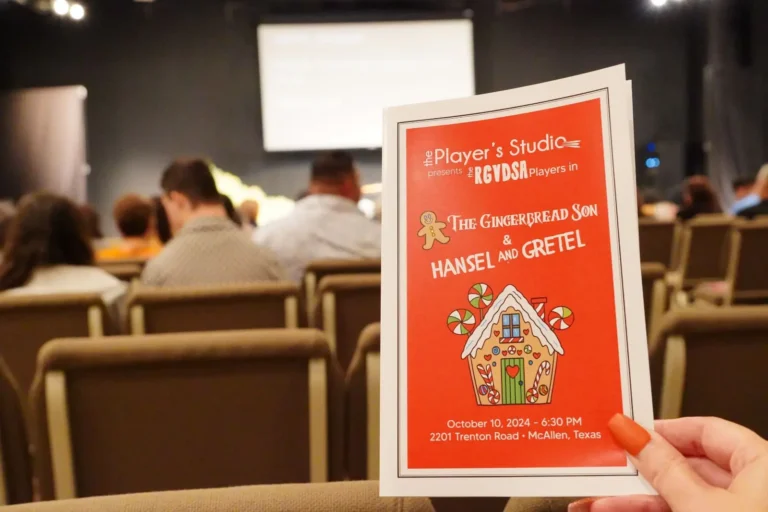 a hand holding a red and white card