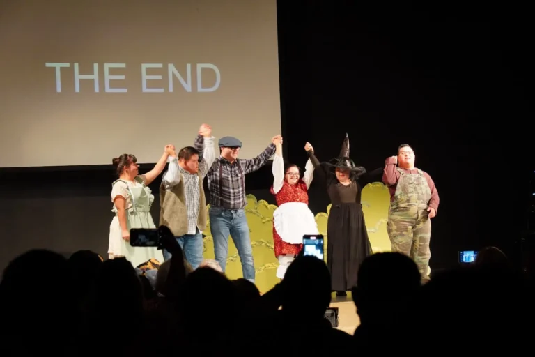 a group of people on stage raising their hands