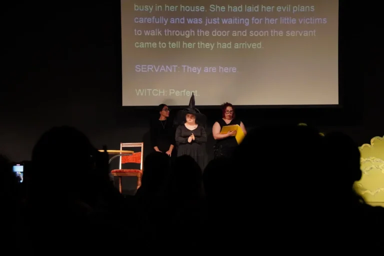 a group of women in a black hat on a stage